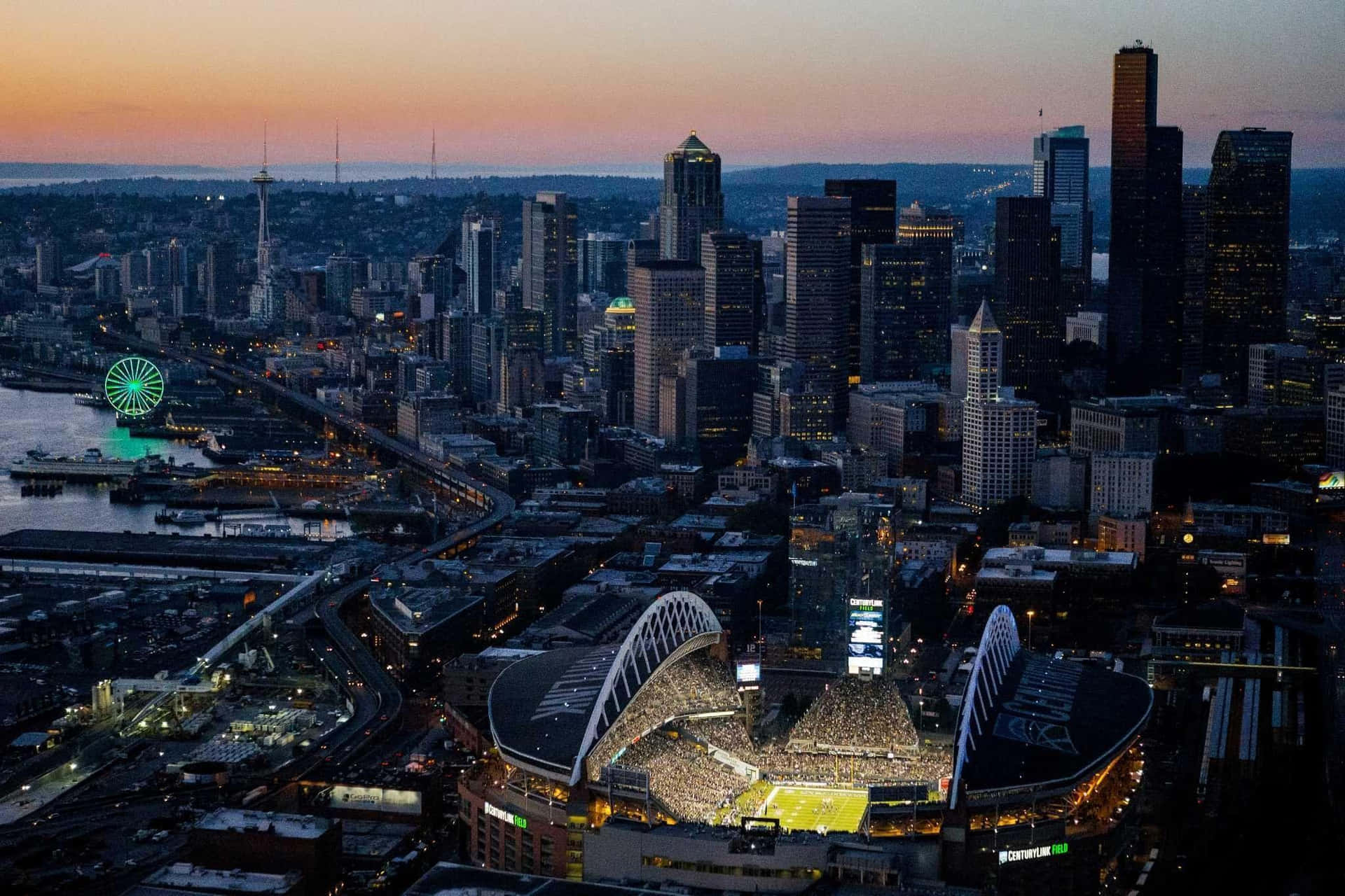 Gnistrende Cityscape af Seattle om Aftenen Wallpaper