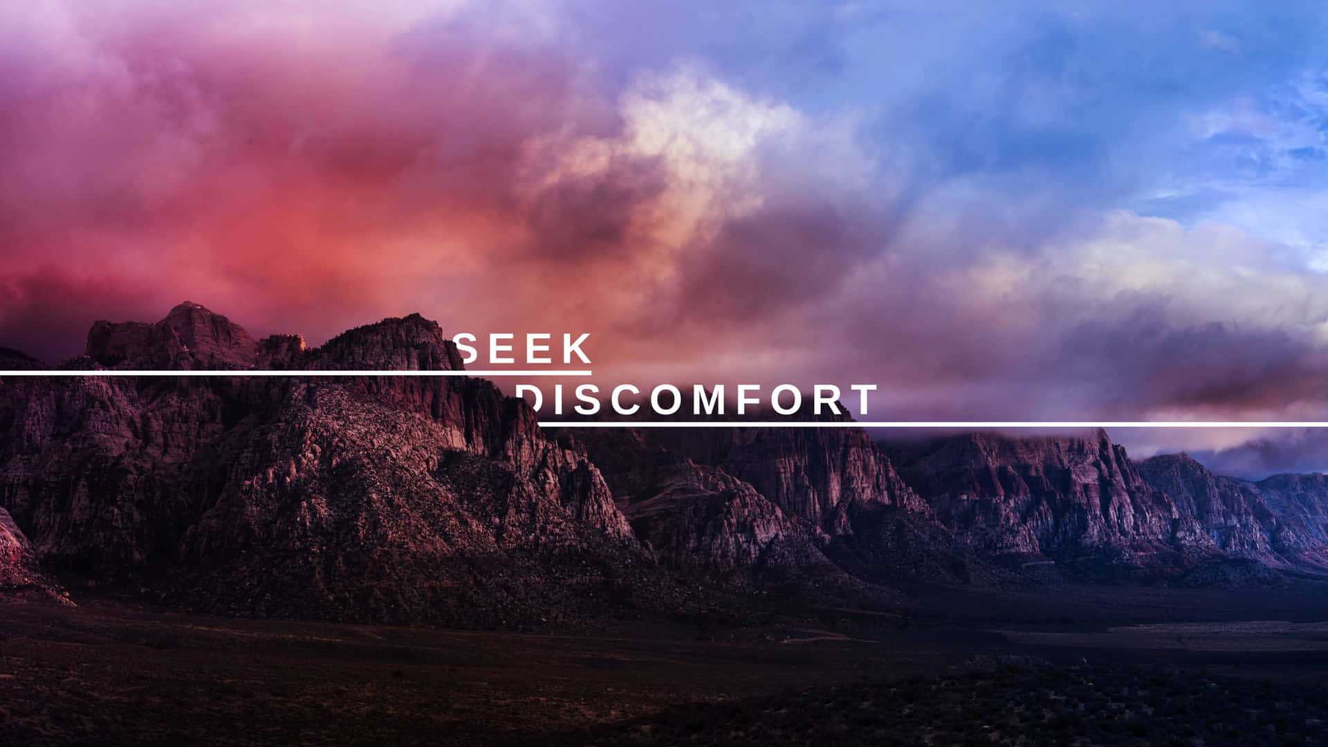A Mountain Range With The Words Seek Discomfort Wallpaper