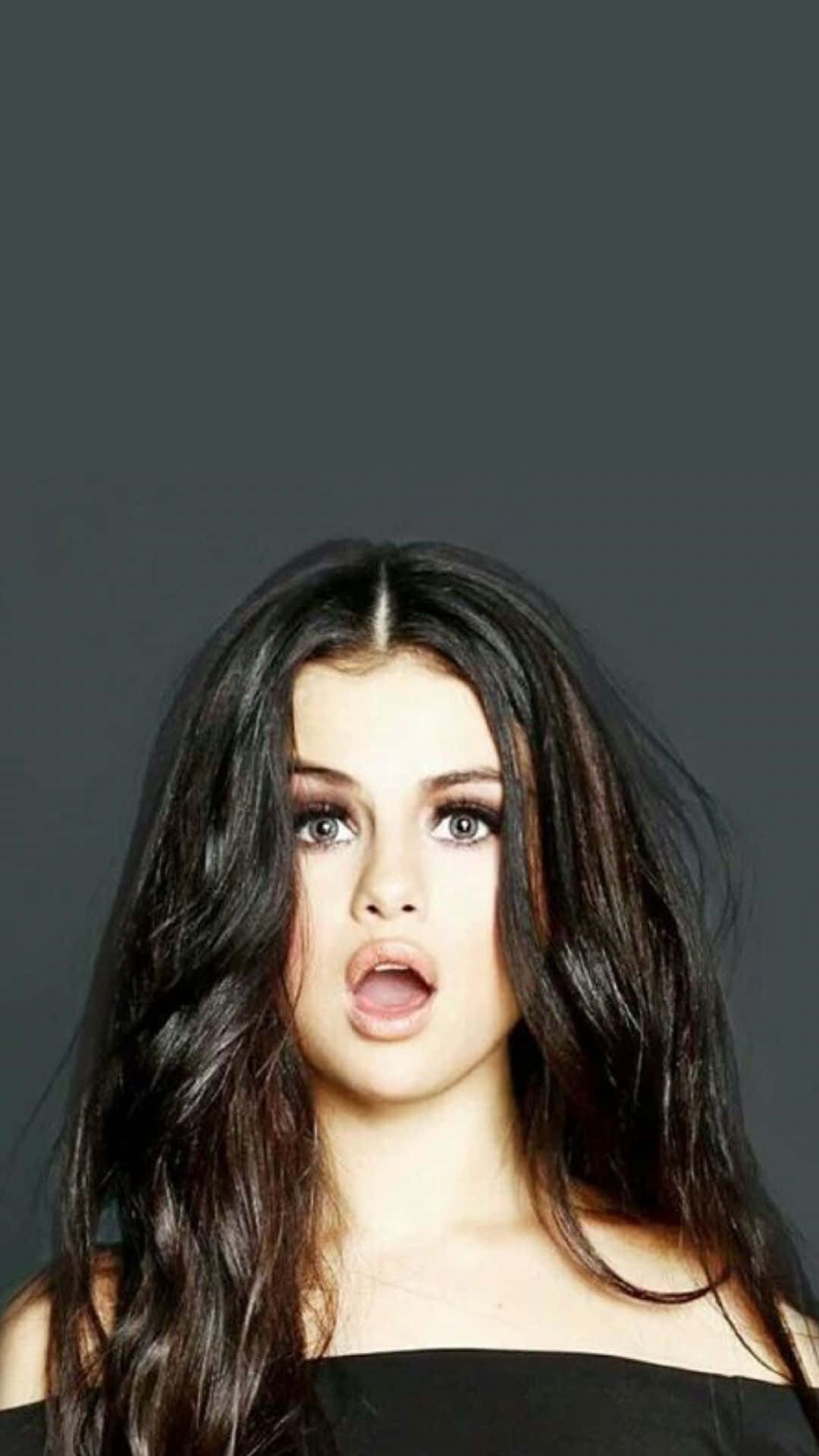 Selena Gomez holder hendes signatur iPhone 8 Plus. Wallpaper