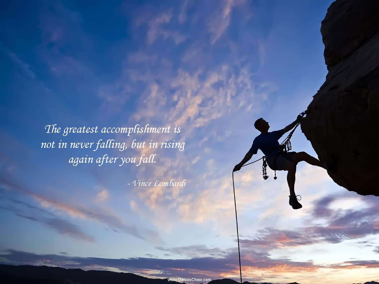En mand klatrer en klippe med et citat Wallpaper