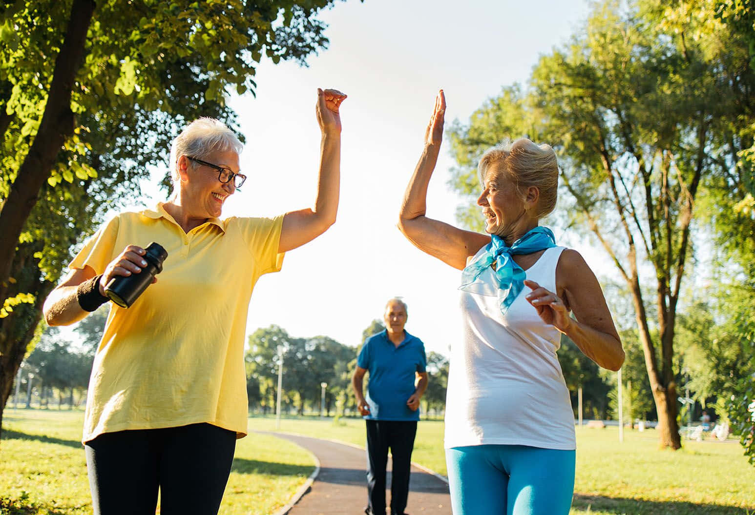 Seniors Enjoying a Vibrant Workout in Sunshine Wallpaper
