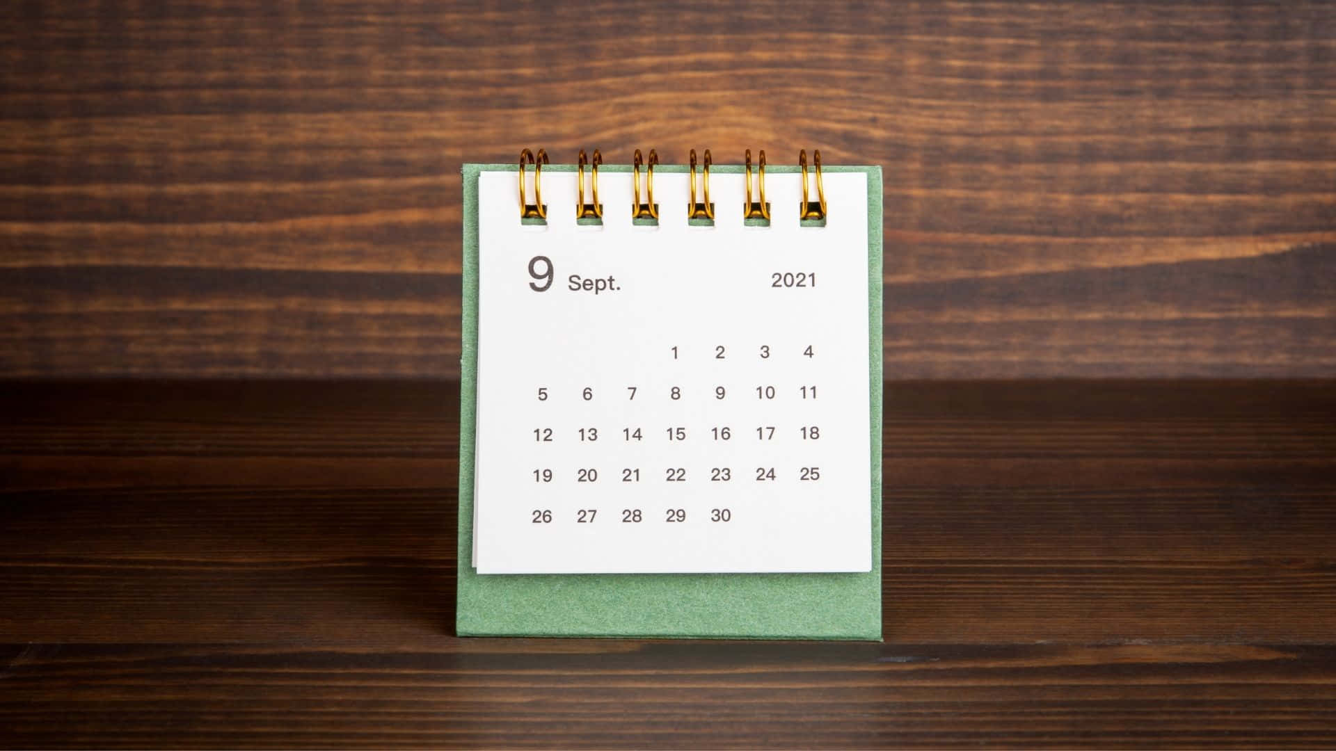 A Calendar On A Wooden Table Wallpaper