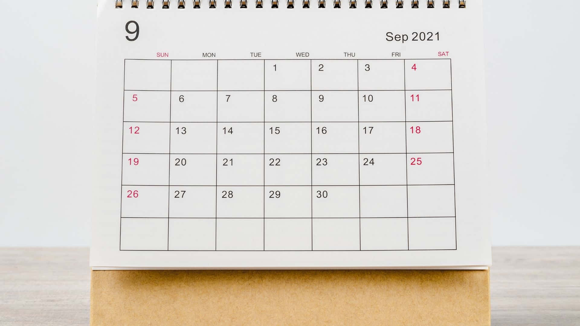 A Calendar With A White Background On A Wooden Table Wallpaper