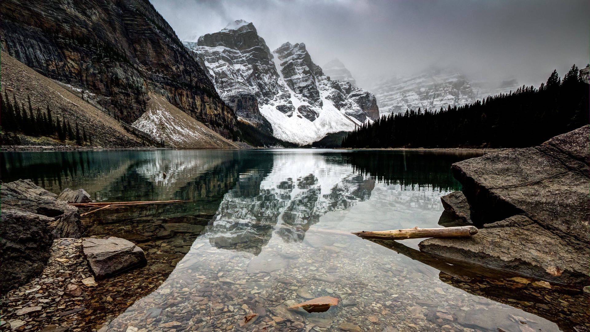 Serene Lake As Snow-Capped Mountains Stretch In The Background Wallpaper