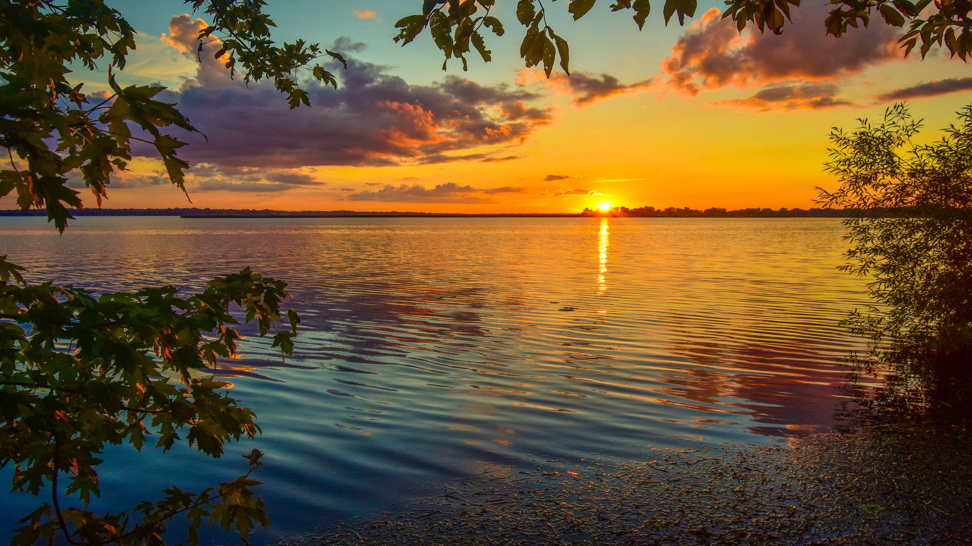 Enjoying the stillness of a peaceful lake sunset Wallpaper