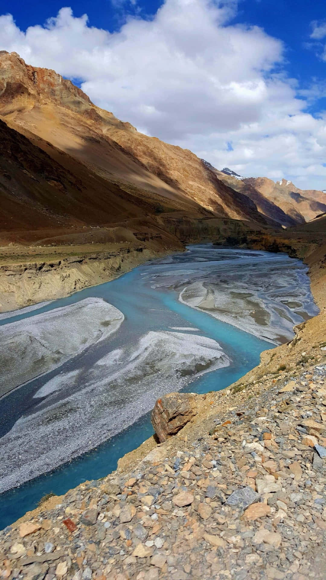 Et flod i bjergene med en blå himmel Wallpaper