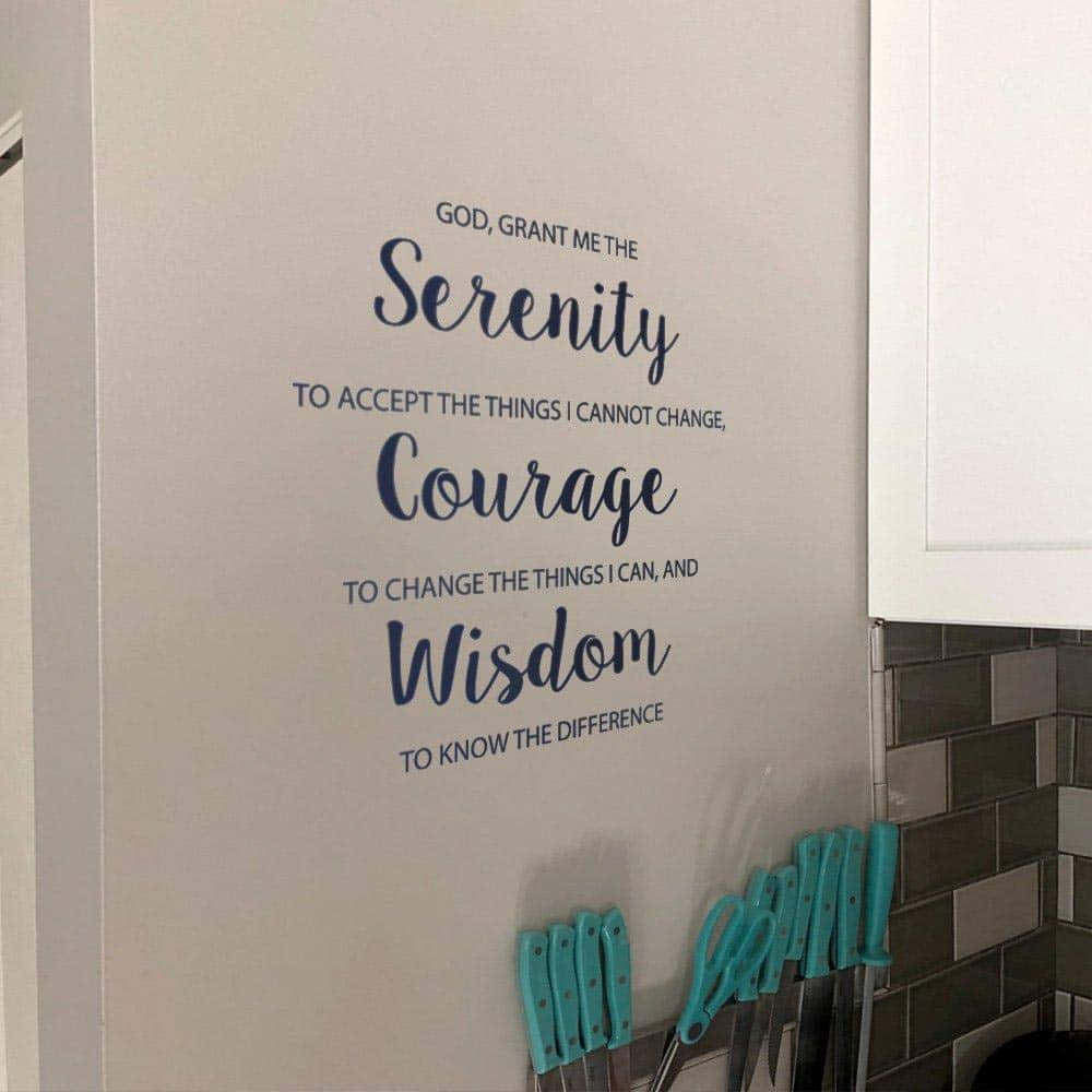 En køkken med en væg dekoration der siger, 'Gud gav mig serenitet til mod og visdom til at ændre de ting jeg kan'. Wallpaper