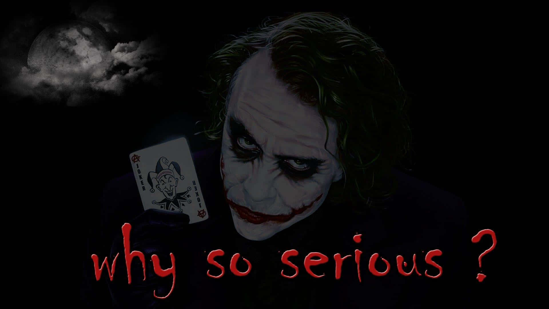 Serious Joker Holding A Joker Card Wallpaper