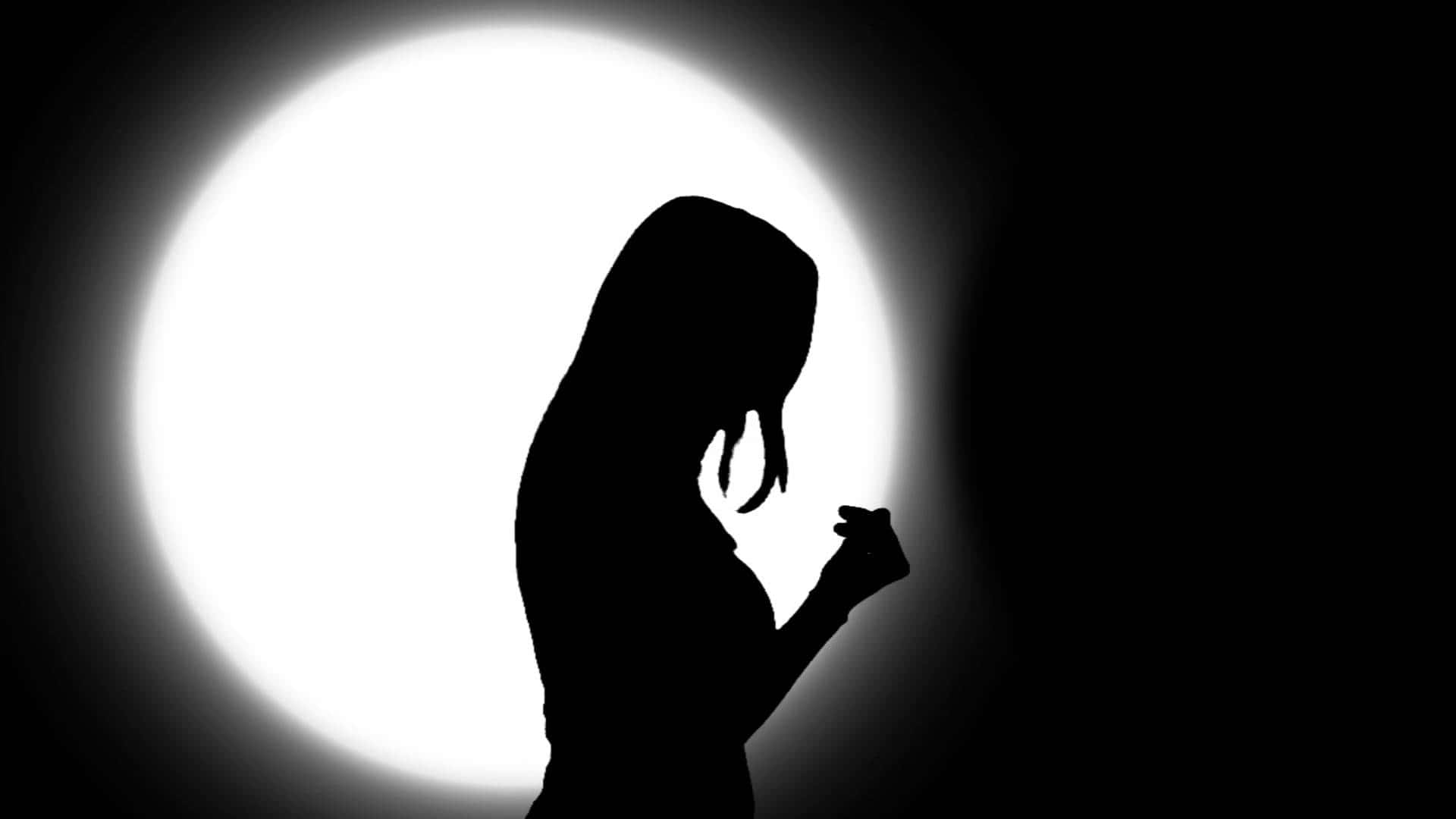 A Silhouette Of A Woman In Front Of A Light