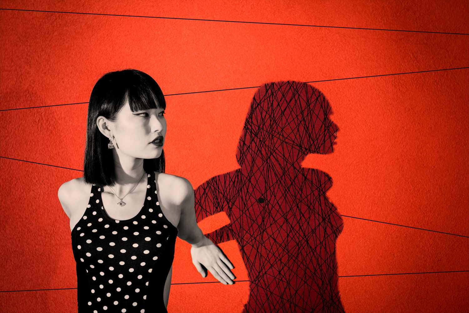 A Woman Is Standing In Front Of A Red Wall With A Shadow