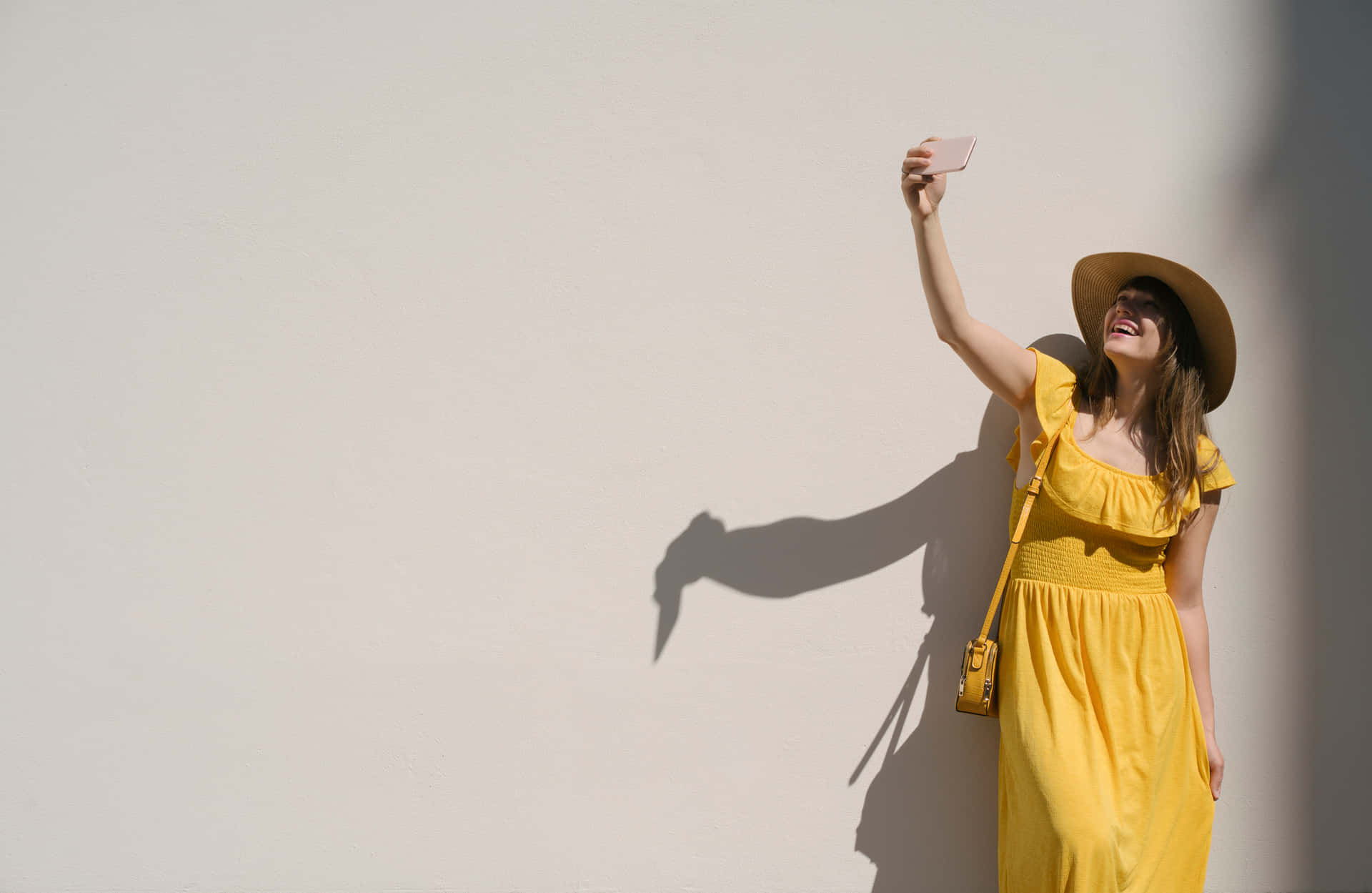 Download Woman Taking Selfie In Yellow Dress | Wallpapers.com