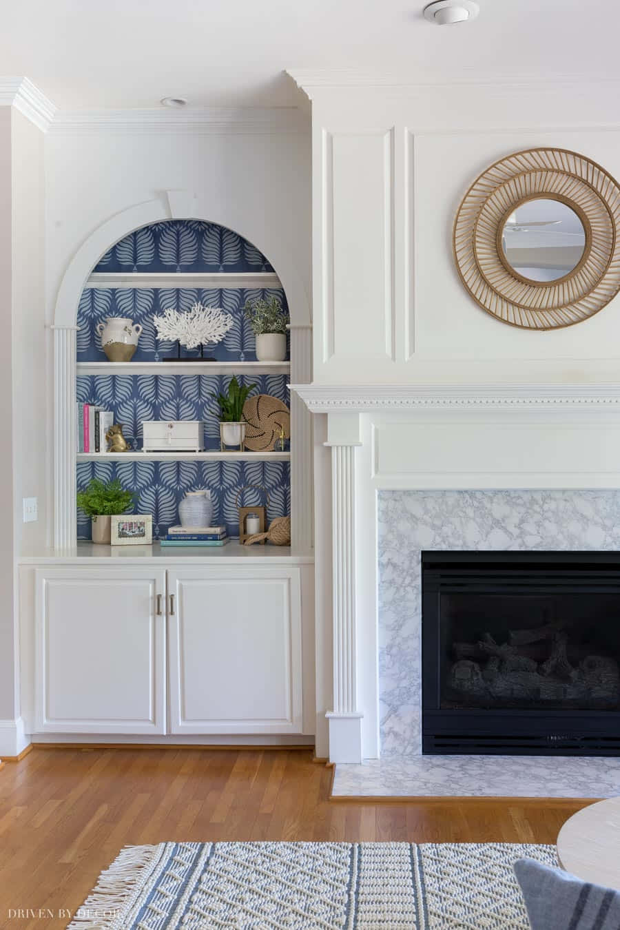 A Living Room With A Fireplace And White Shelves