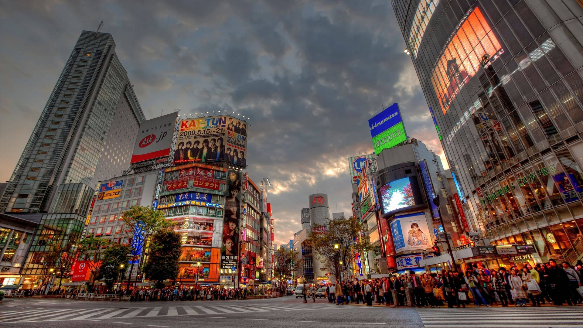 The hustle and bustle of Shibuya Crossing at sunset in Tokyo, Japan Wallpaper