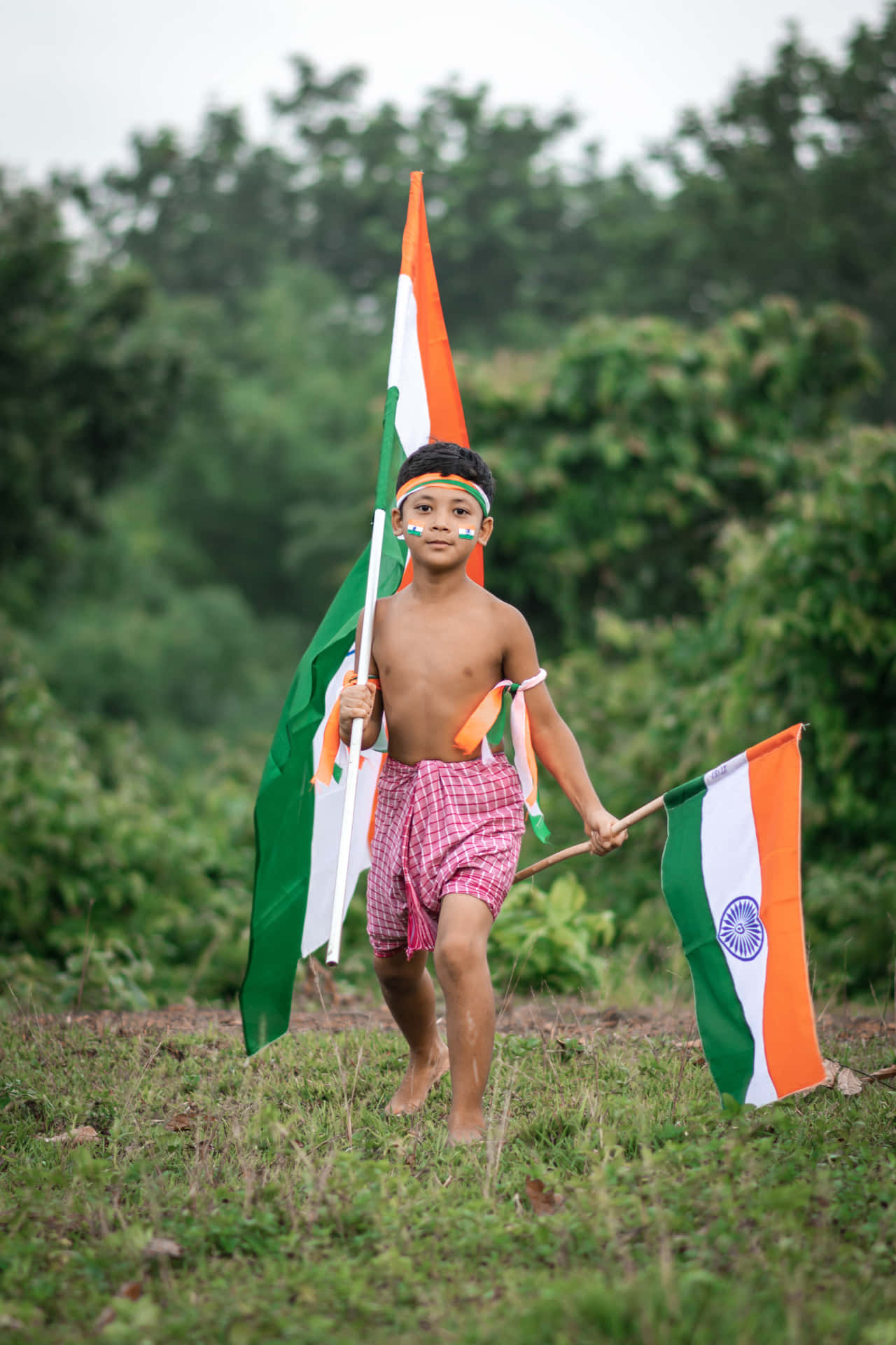Bildpå En Indisk Pojke Utan Skjorta Som Håller I Flaggor