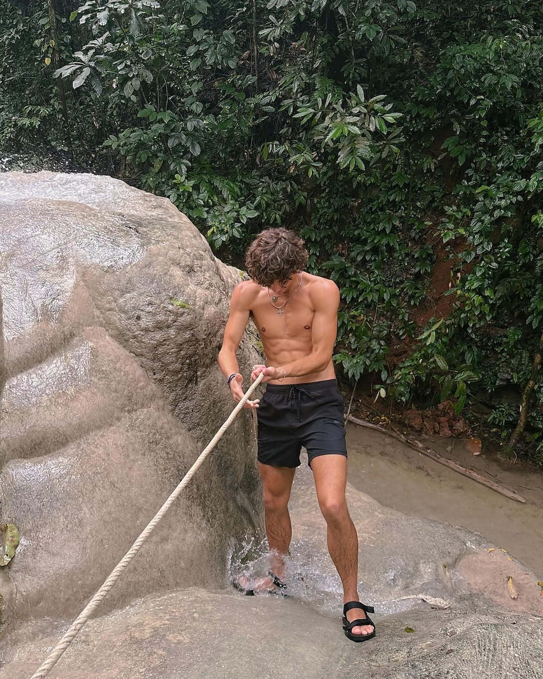 Shirtless Man Climbing Rock With Rope Wallpaper