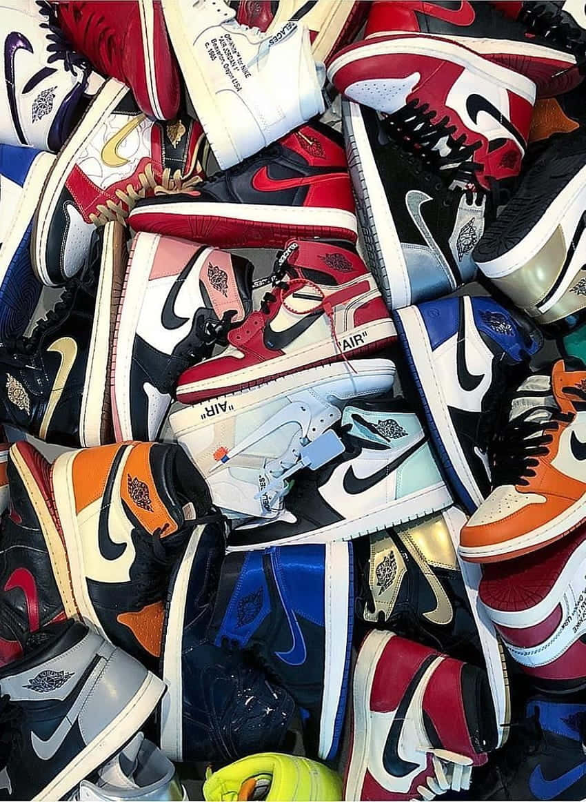 En bunke af sneakers arrangeret i en bunke Wallpaper