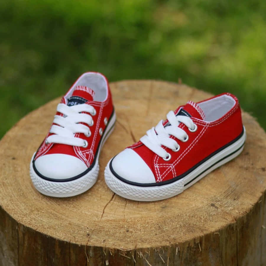 A Pair Of Red Sneakers On A Stump