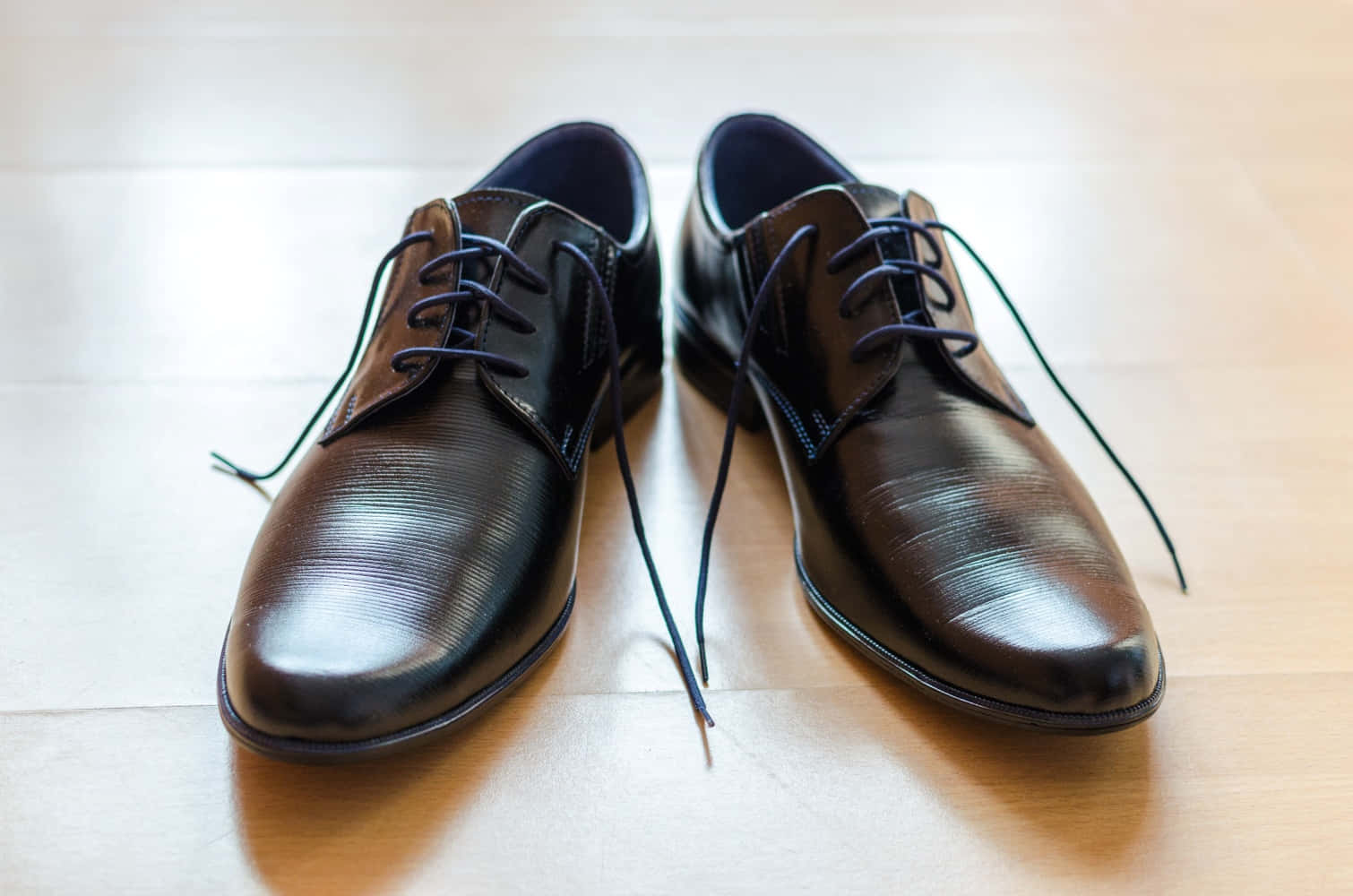 Black Shoes With Blue Laces On A Wooden Floor