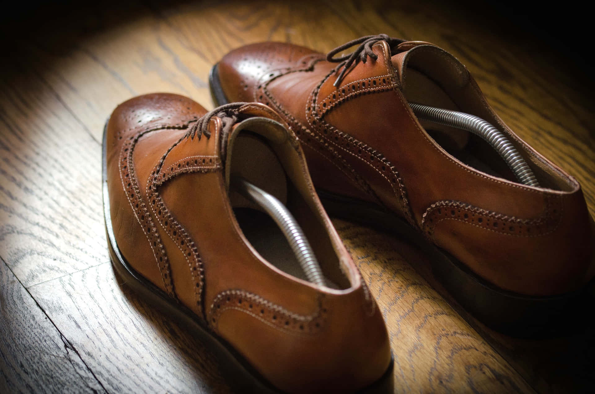 A Pair Of Brown Shoes On A Wooden Floor