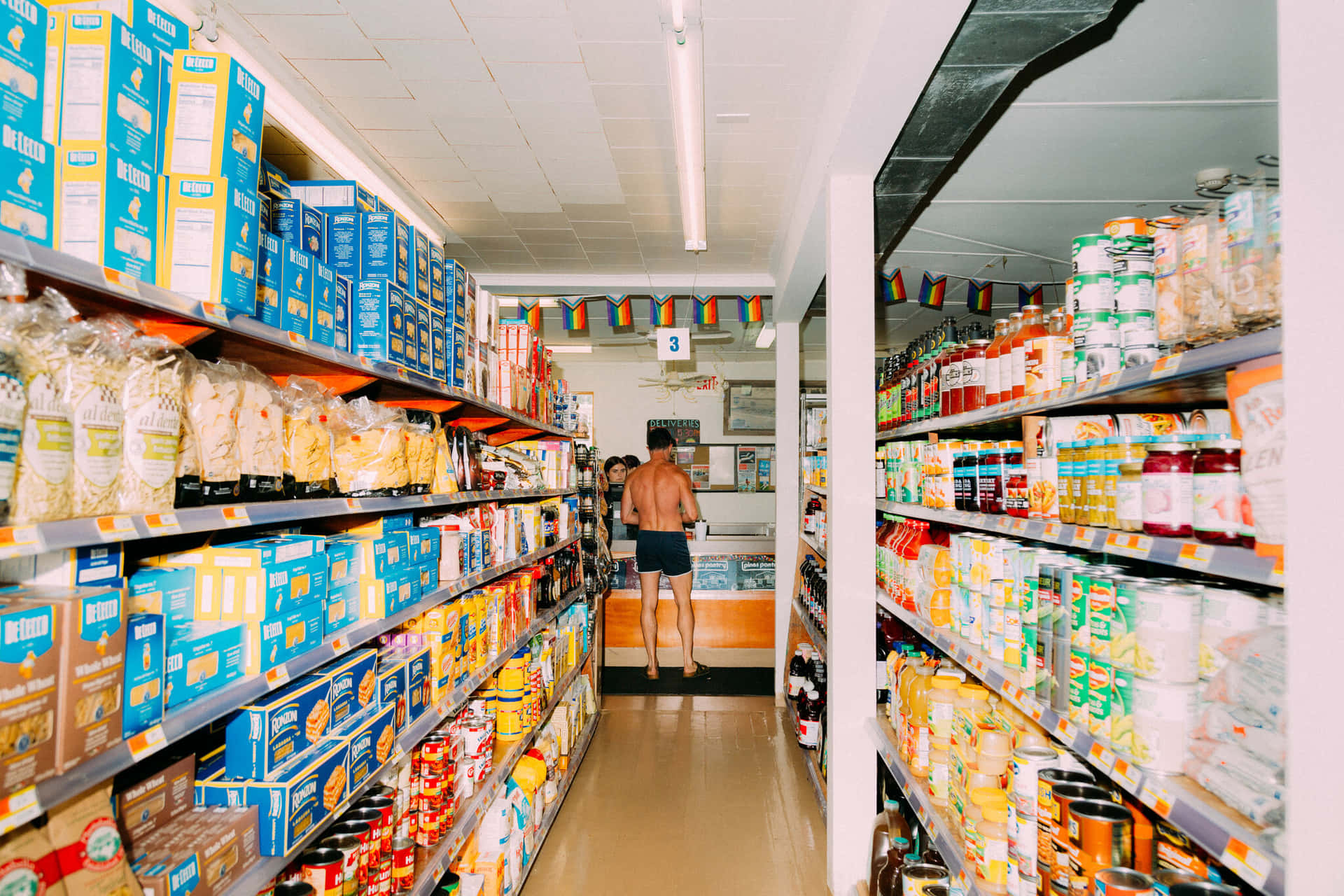 A Man Is Standing In A Grocery Store Aisle