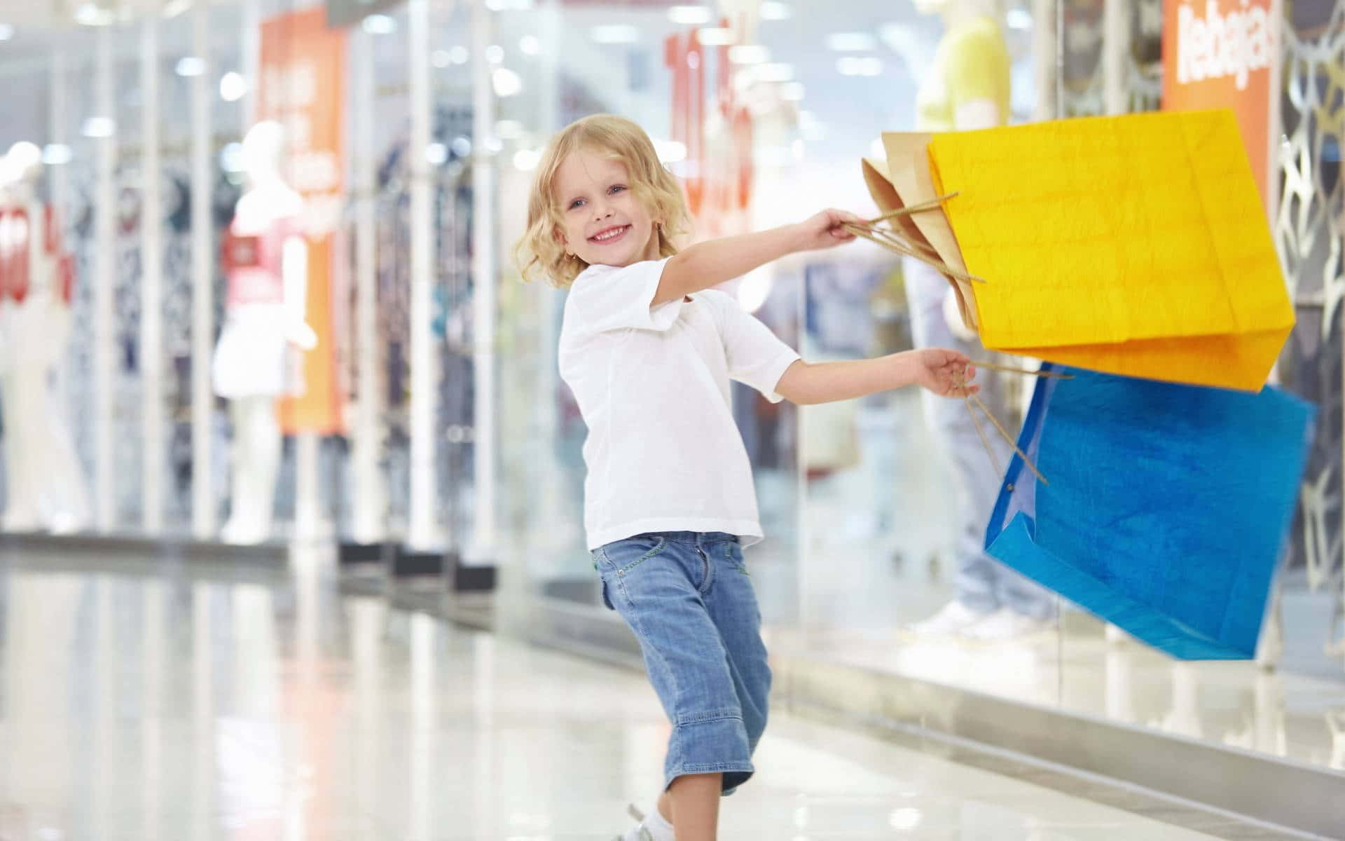 Einkleines Mädchen Hält Einkaufstaschen In Einer Einkaufspassage.