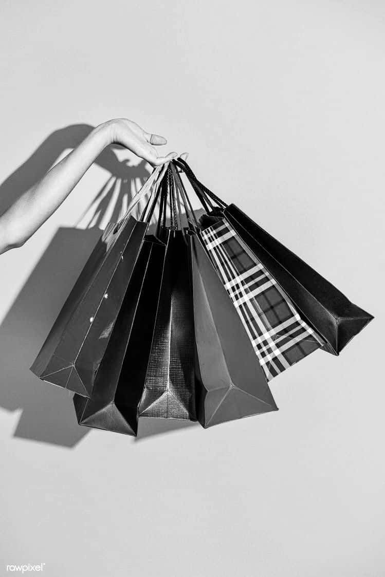 Black And White Photo Of A Woman Holding Shopping Bags