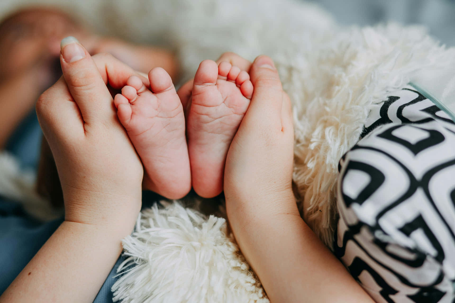 Sibling Bonding Moment Baby Feet Wallpaper