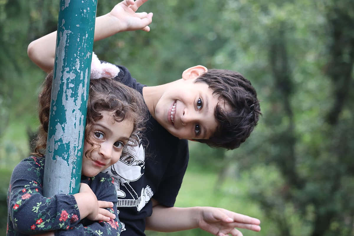 Siblings Enjoying Outdoor Playtime Wallpaper