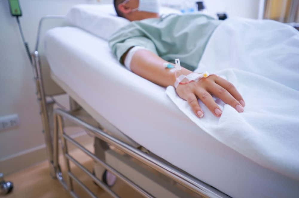 A Patient Is Lying In A Hospital Bed