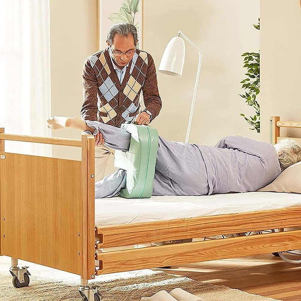 A Man Helping An Elderly Woman Into A Bed