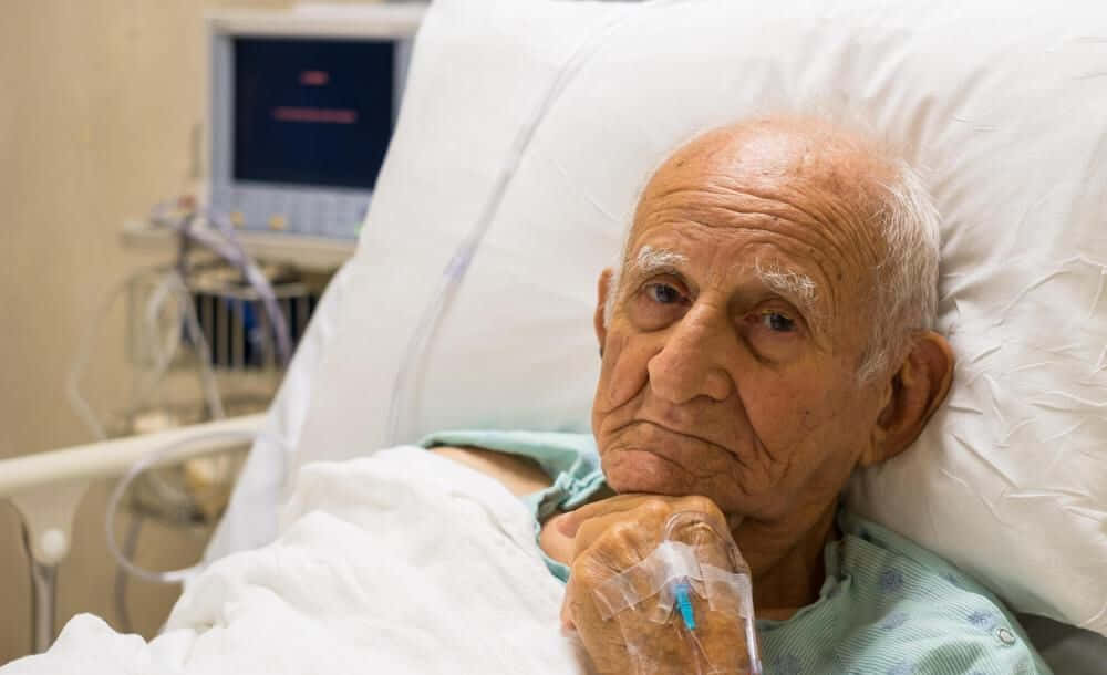 An Elderly Man In A Hospital Bed