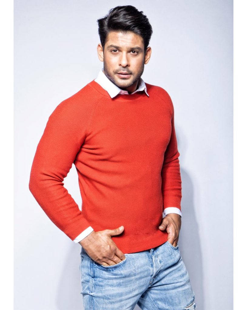 Sidharth Shukla In Red Sweater Standing Sideways Wallpaper