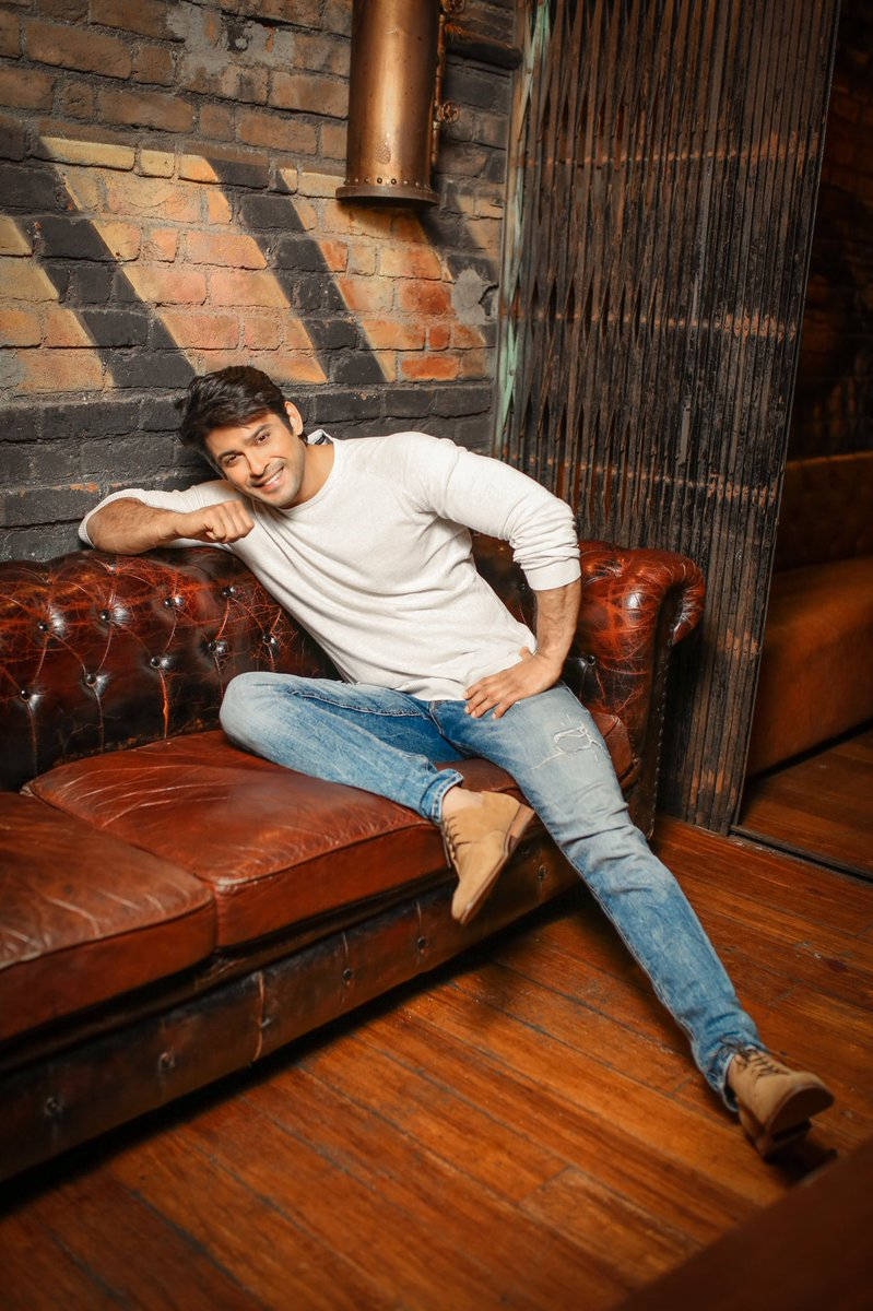 Sidharth Shukla Sitting On A Chesterfield Sofa Wallpaper
