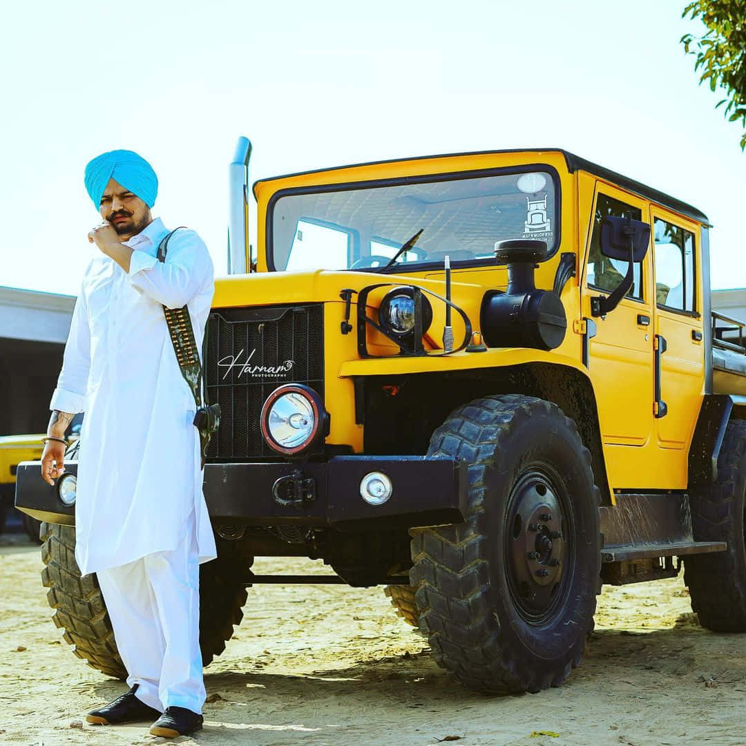A Man Standing Next To A Yellow Jeep