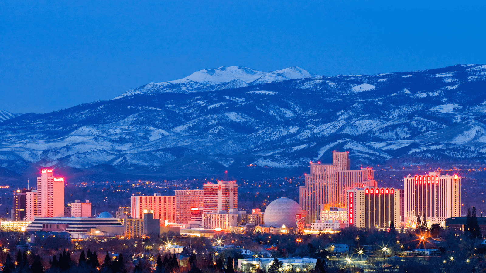 A scenic skyline of Reno, Nevada, with the Sierra Nevada Range in the backdrop Wallpaper