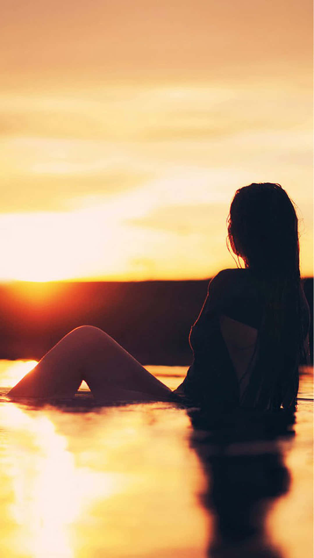 Silhuet af pige på guld solnedgang på stranden Wallpaper