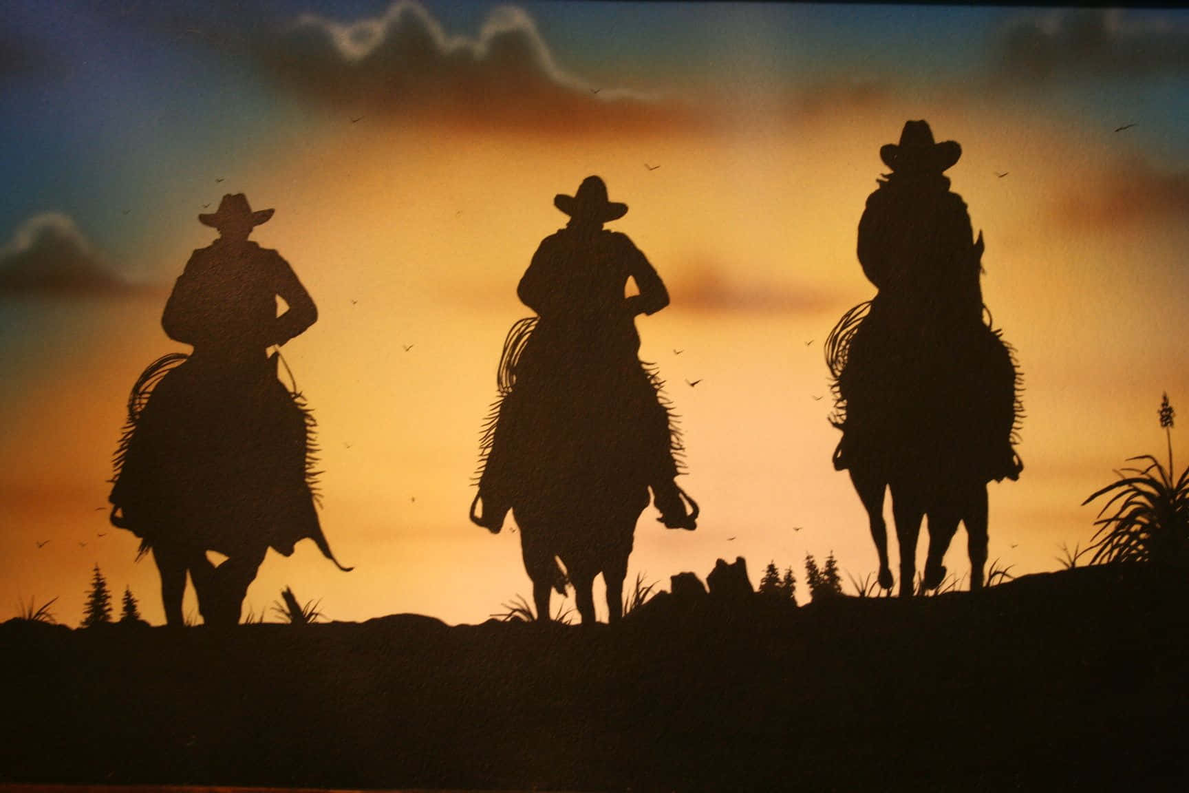 Silhouetted Cowboysat Sunset Wallpaper