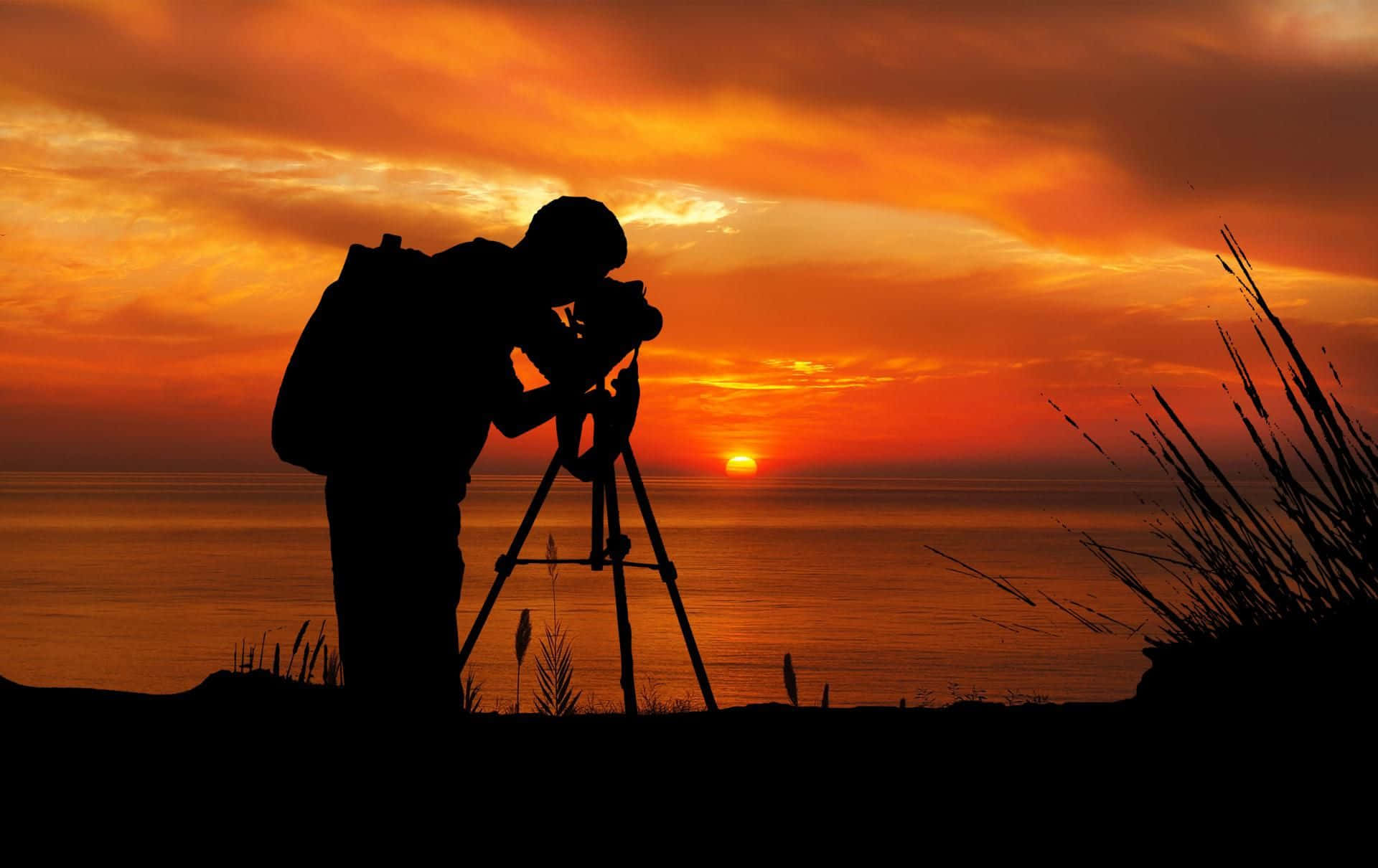 Silhouetted Photographerat Sunset Wallpaper