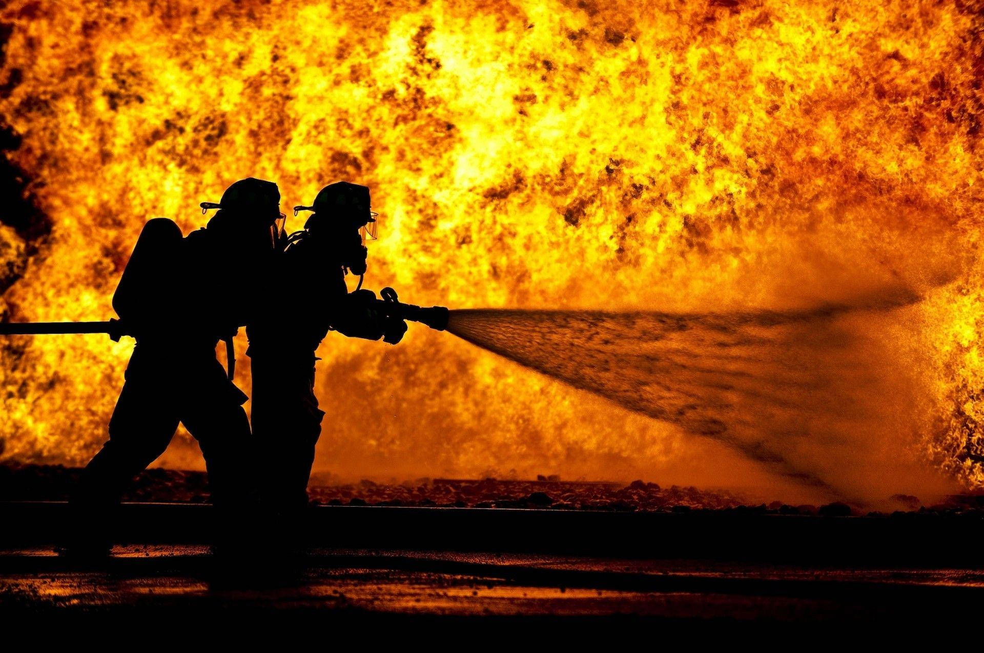 Silhouettes Of Firefighters Putting Out Fire Wallpaper