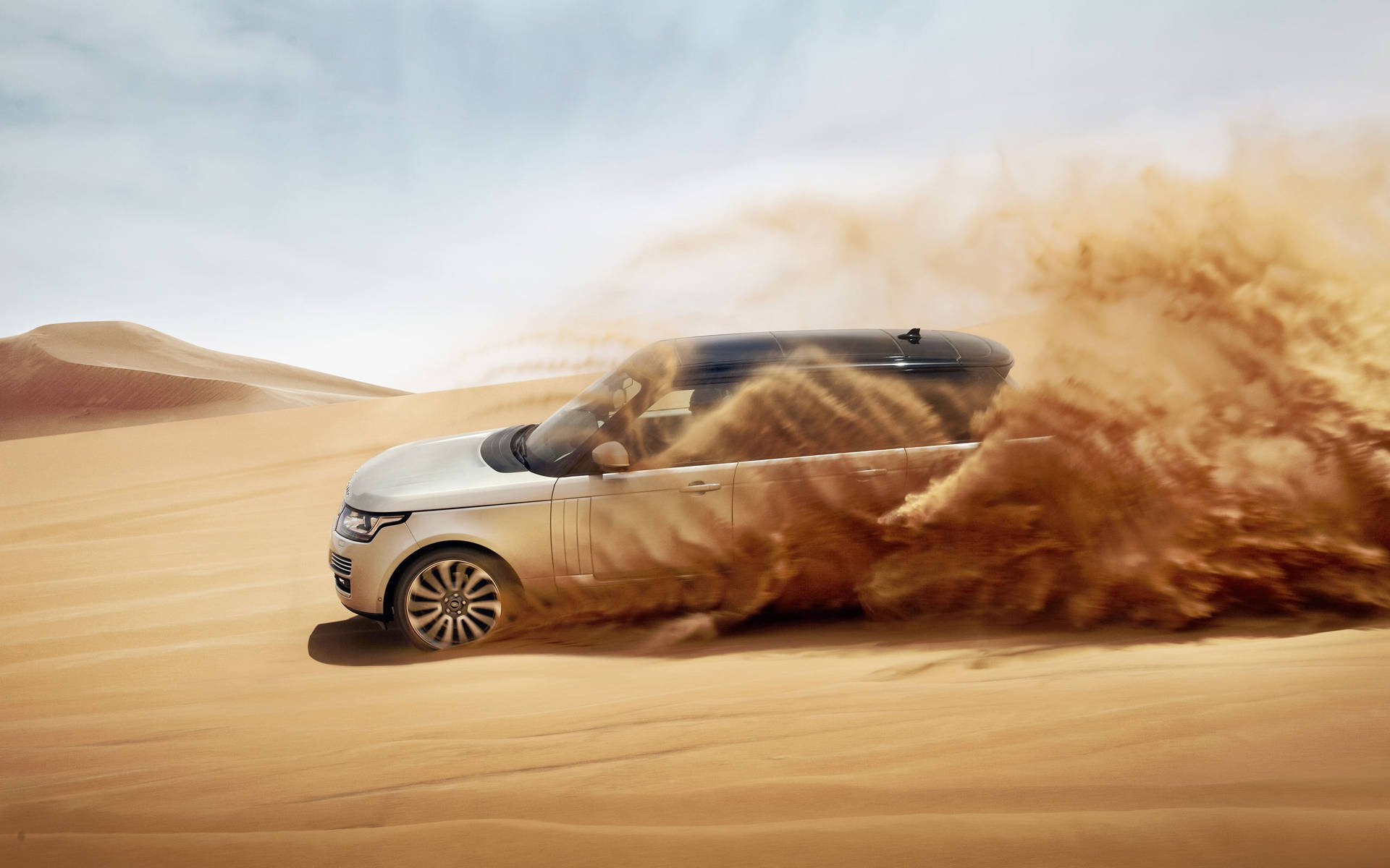 A Luxurious Land Rover Glides Across the Sand of the Desert Wallpaper