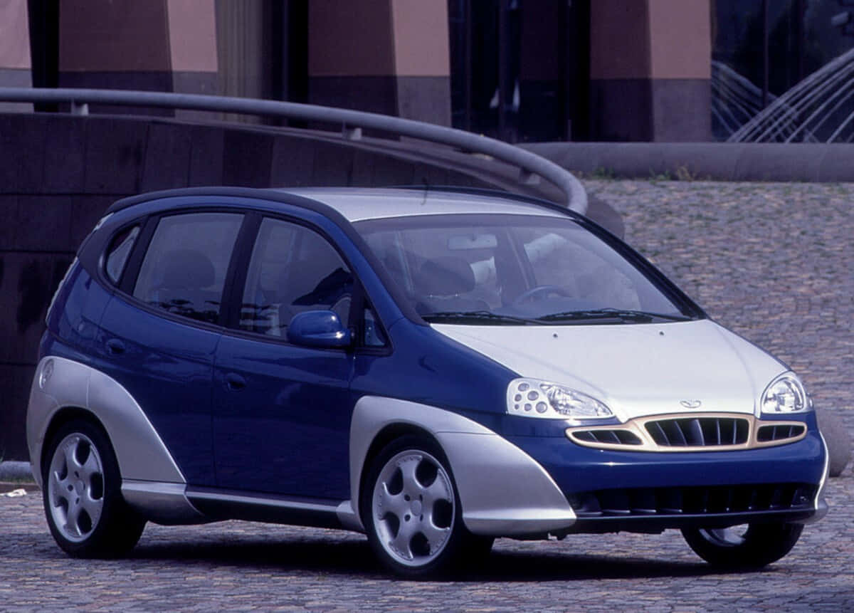 Silver Daewoo Tacuma Against A Scenic Background Wallpaper