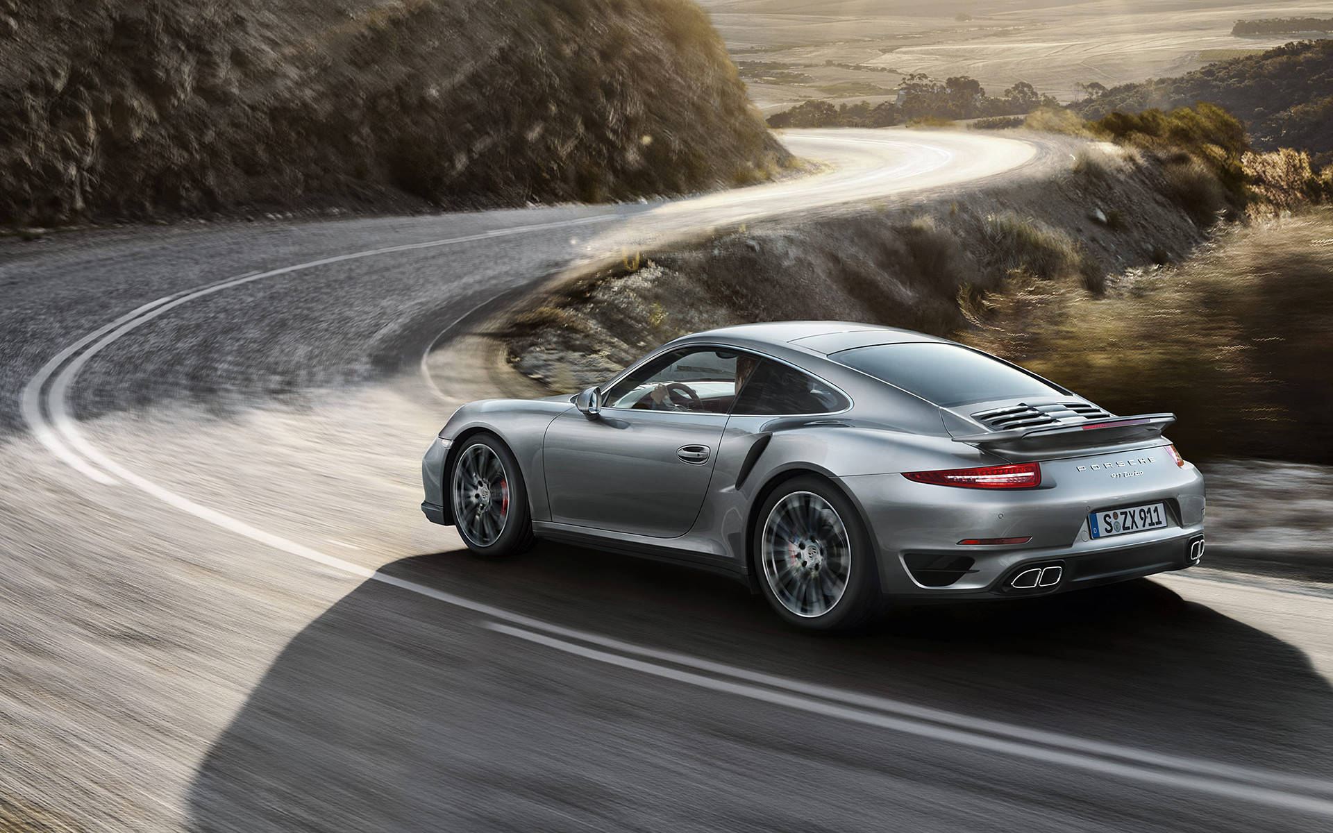 Silver Porsche 911 Speeding Down Road Wallpaper