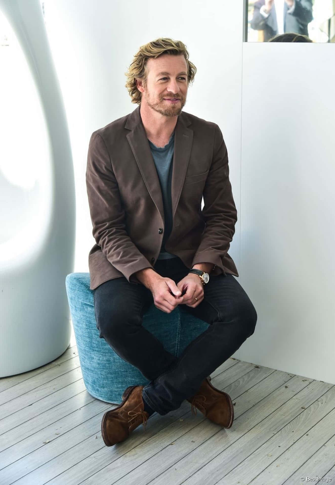 Simon Baker Smiling Casually Seated Wallpaper