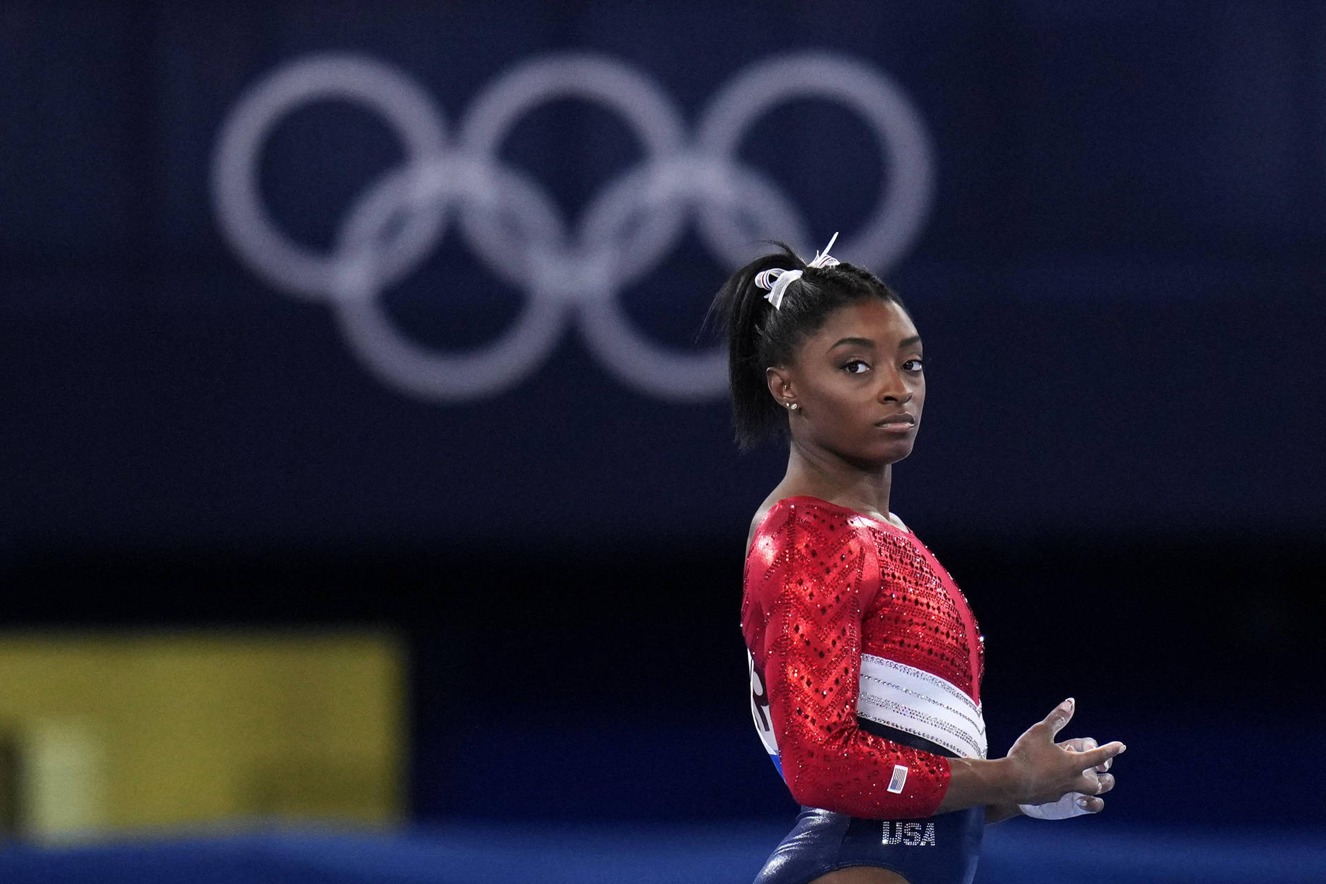 Simone Biles in Mid-air Execution at the Olympics Wallpaper