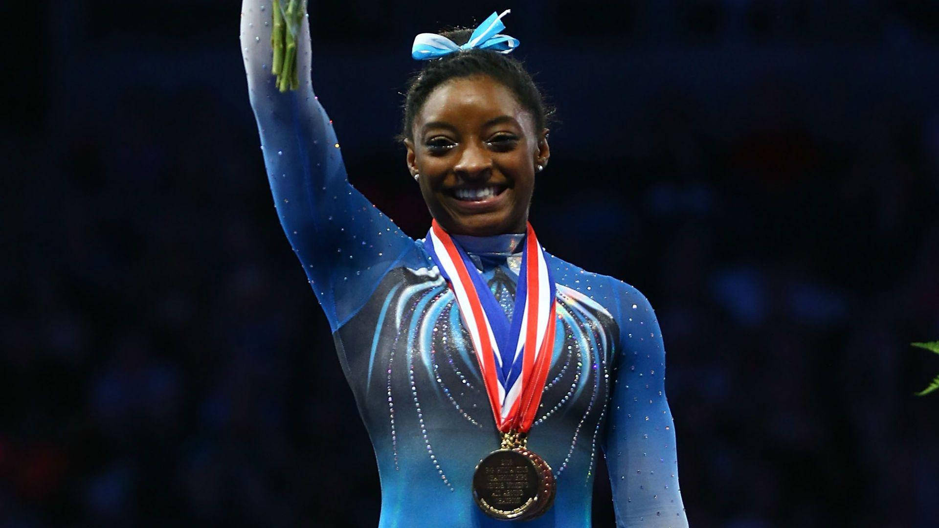 Olympic Gold Medal Gymnast Simone Biles Flawlessly Executing Her Routine Wallpaper