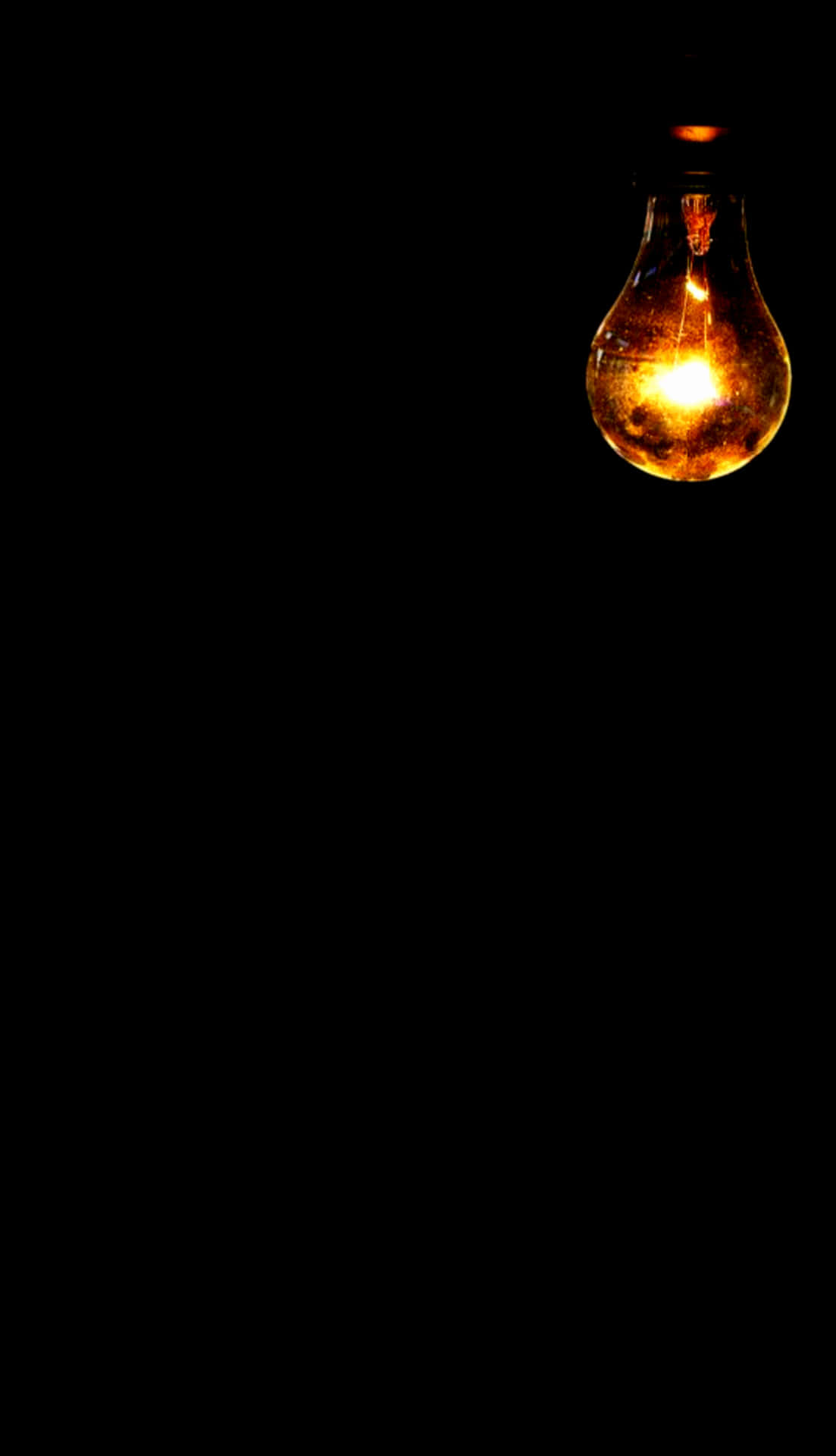 A Light Bulb Is Lit Up In The Dark Wallpaper