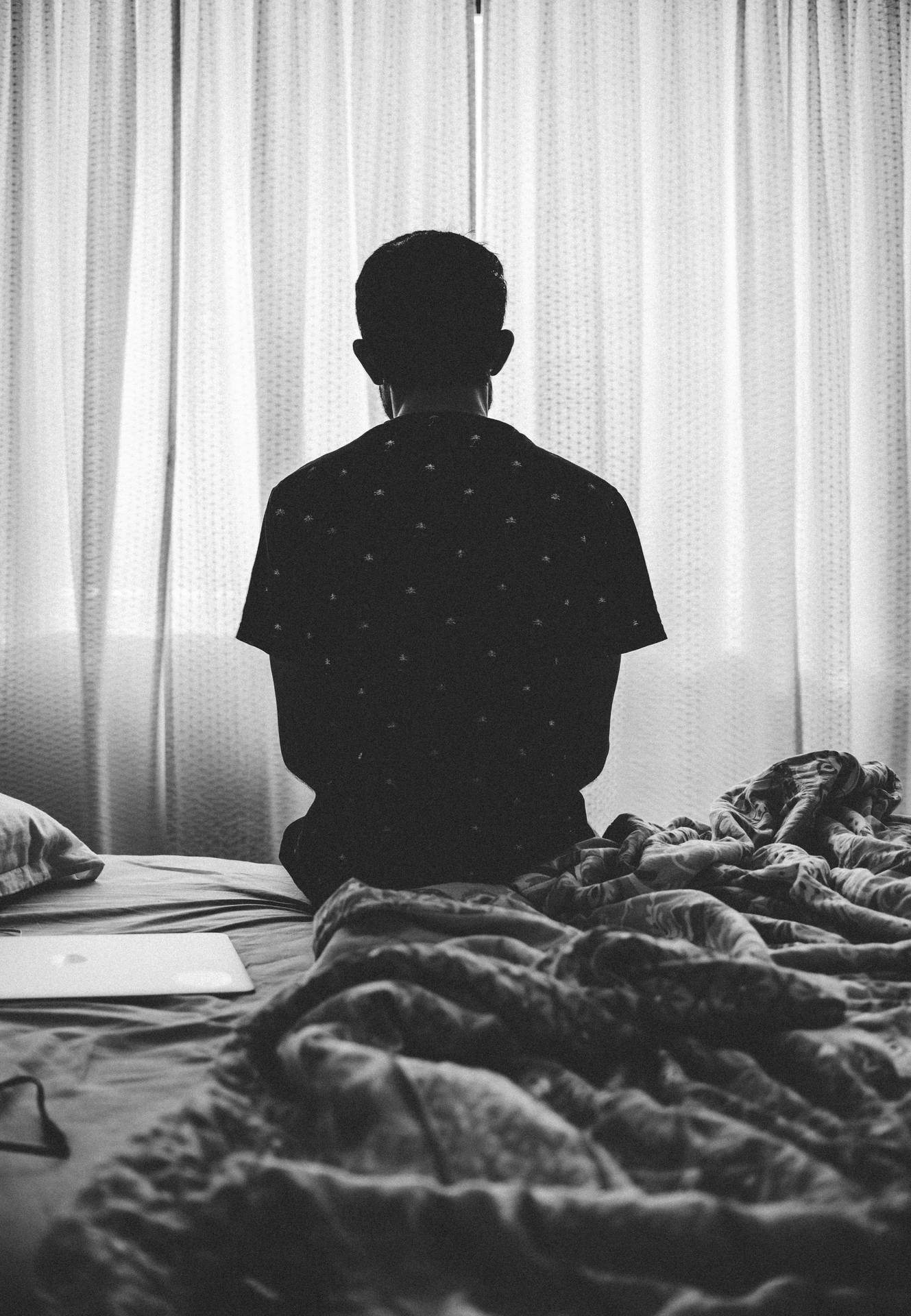 Enlig dreng sidder på sengen Wallpaper
