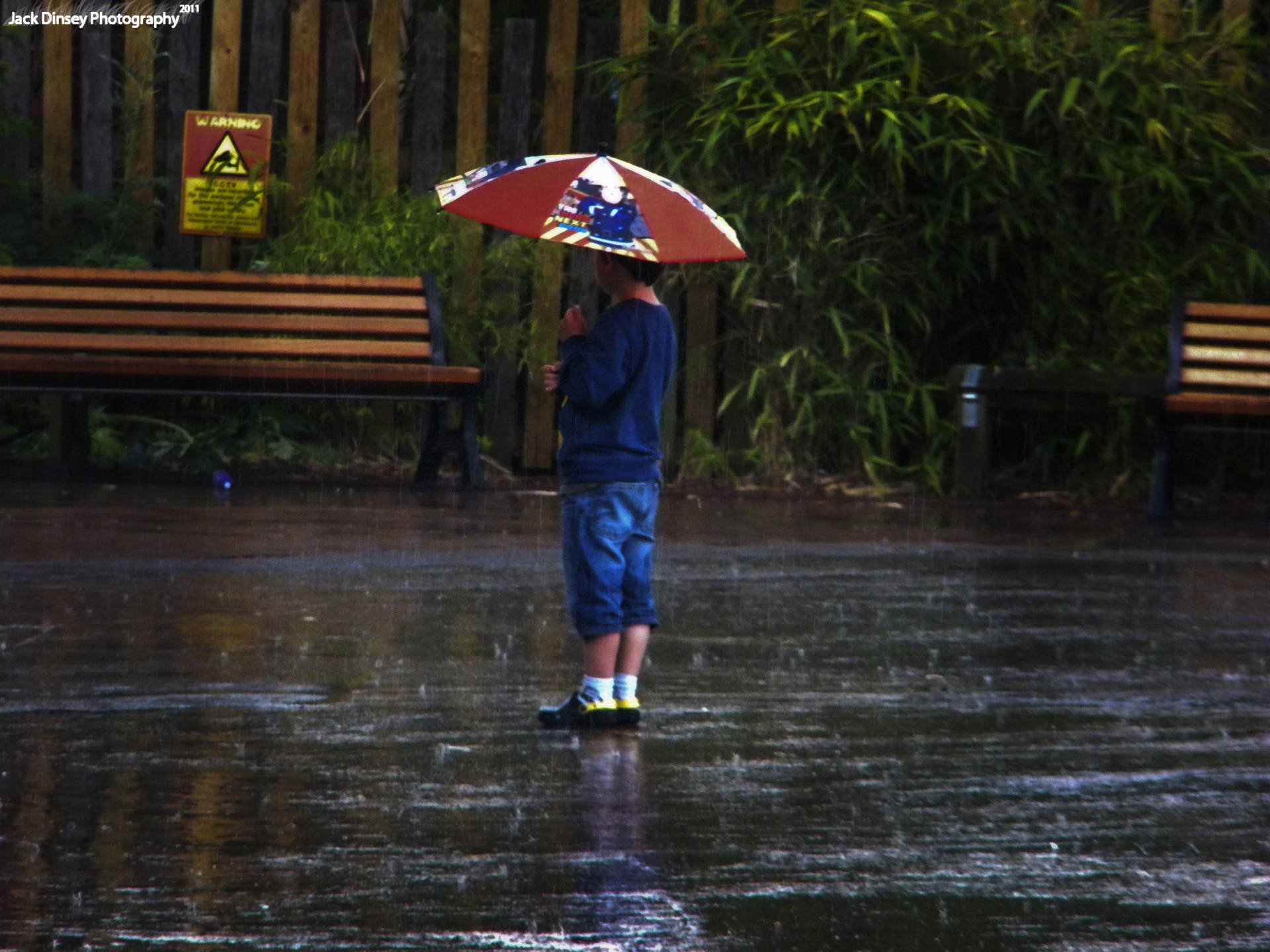 En dreng med paraply i regn Wallpaper