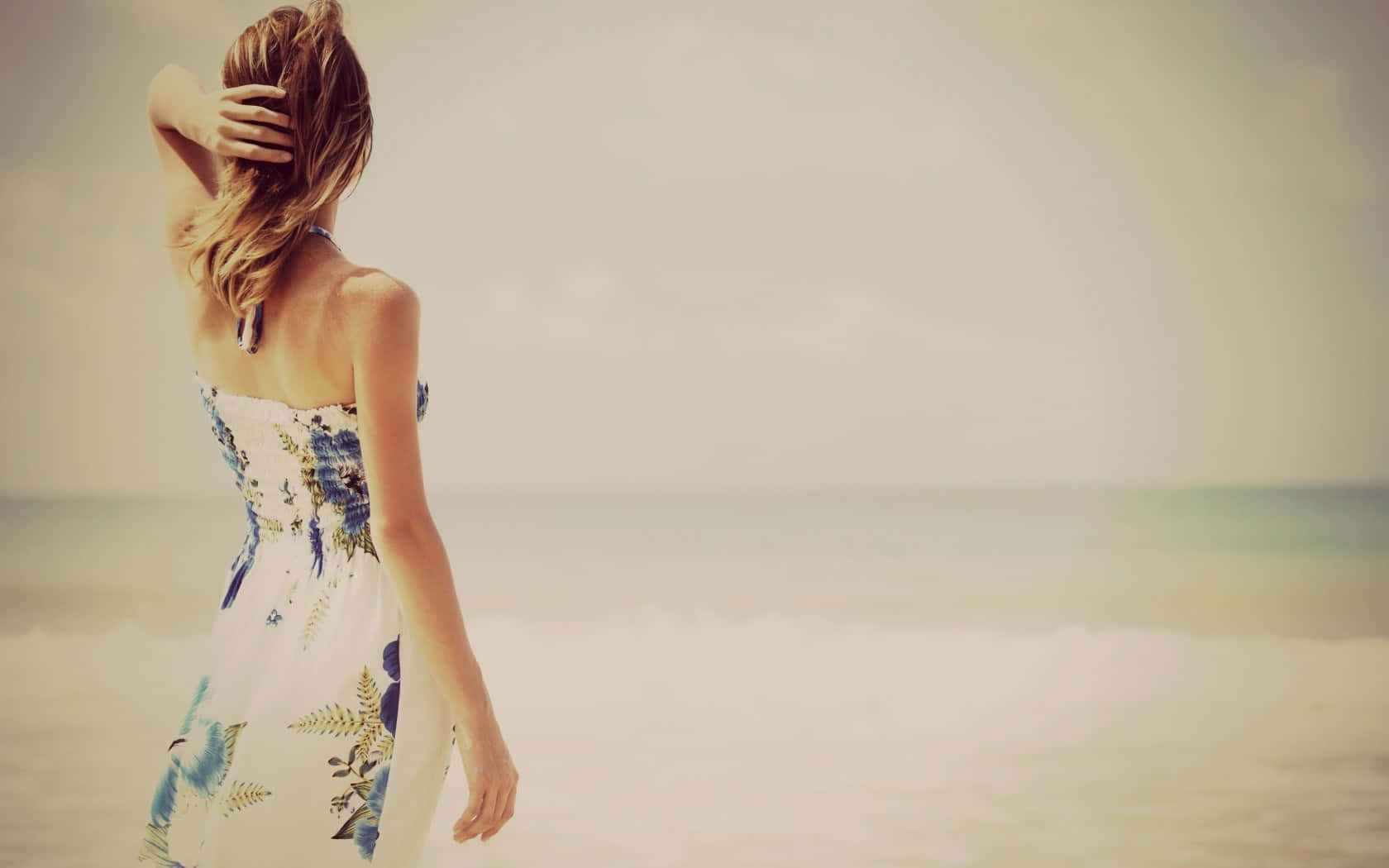 Enkelt kvinde i en strand kjole, der viser hendes smil Wallpaper