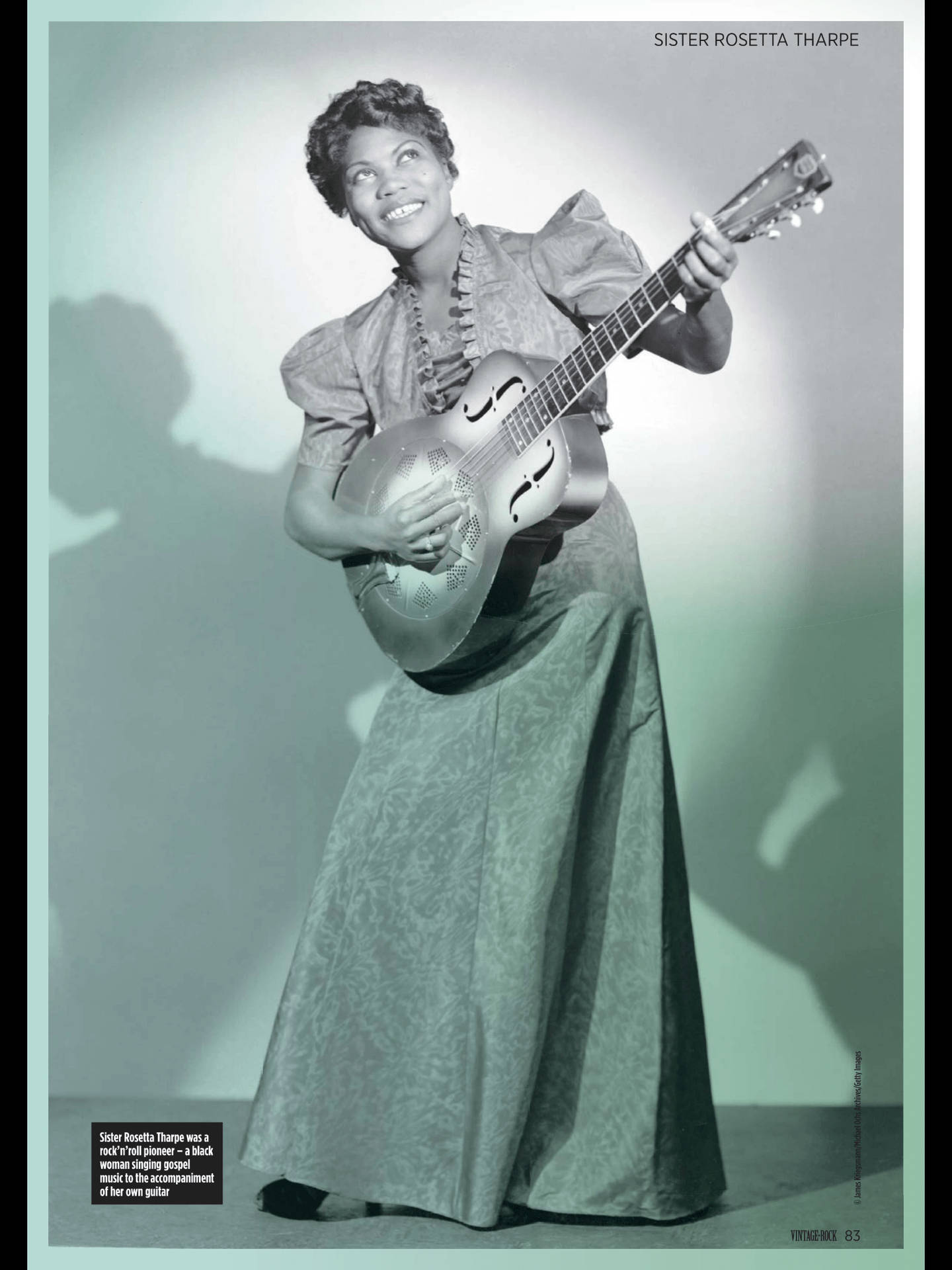 Fotovægafbillede af Sister Rosetta Tharpe, der spiller guitar. Wallpaper